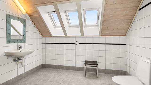 Badet fremstår lyst og funksjonelt, med god plass til både badekar, servant og øvrig innredning.