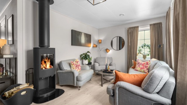 Stua i 1. etasje har en praktisk peisovn som effektivt varmer opp etasjen. Den sentrale plasseringen gir også god varme til 2. etasje.