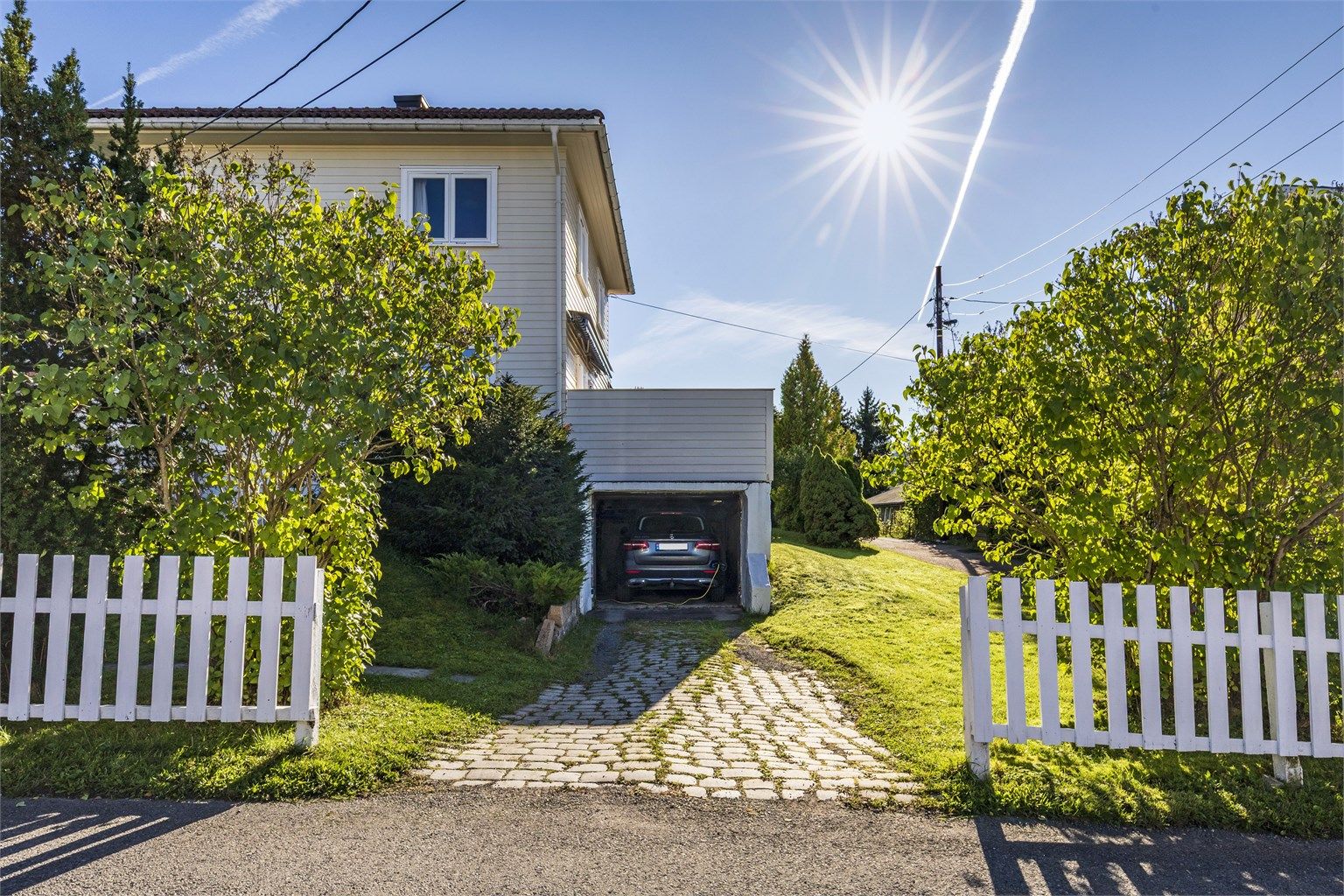 Boligen har en garasje/carport med lav takhøyde. Det er også plass til å parkere bilen i innkjørselen 