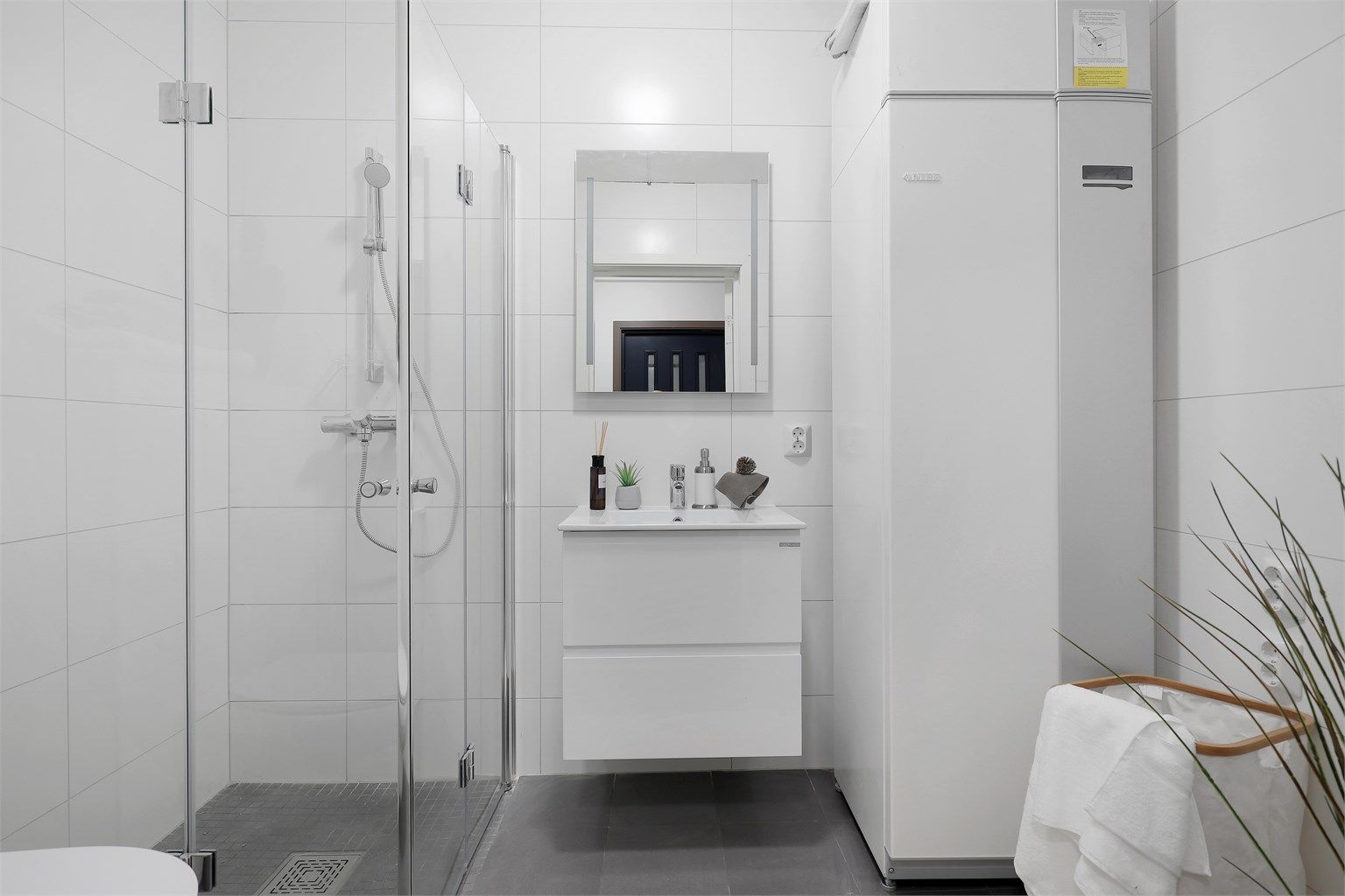 Flislagt og pent bad med varme i gulvet. Det er opplegg for vaskemaskin. 