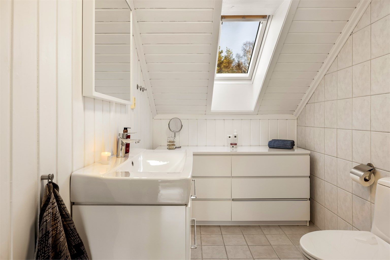 Badet i andre etasje har flislagt gulv med varmekabler og servant med god skuffeplass.