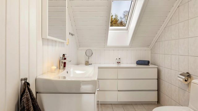 Badet i andre etasje har flislagt gulv med varmekabler og servant med god skuffeplass.