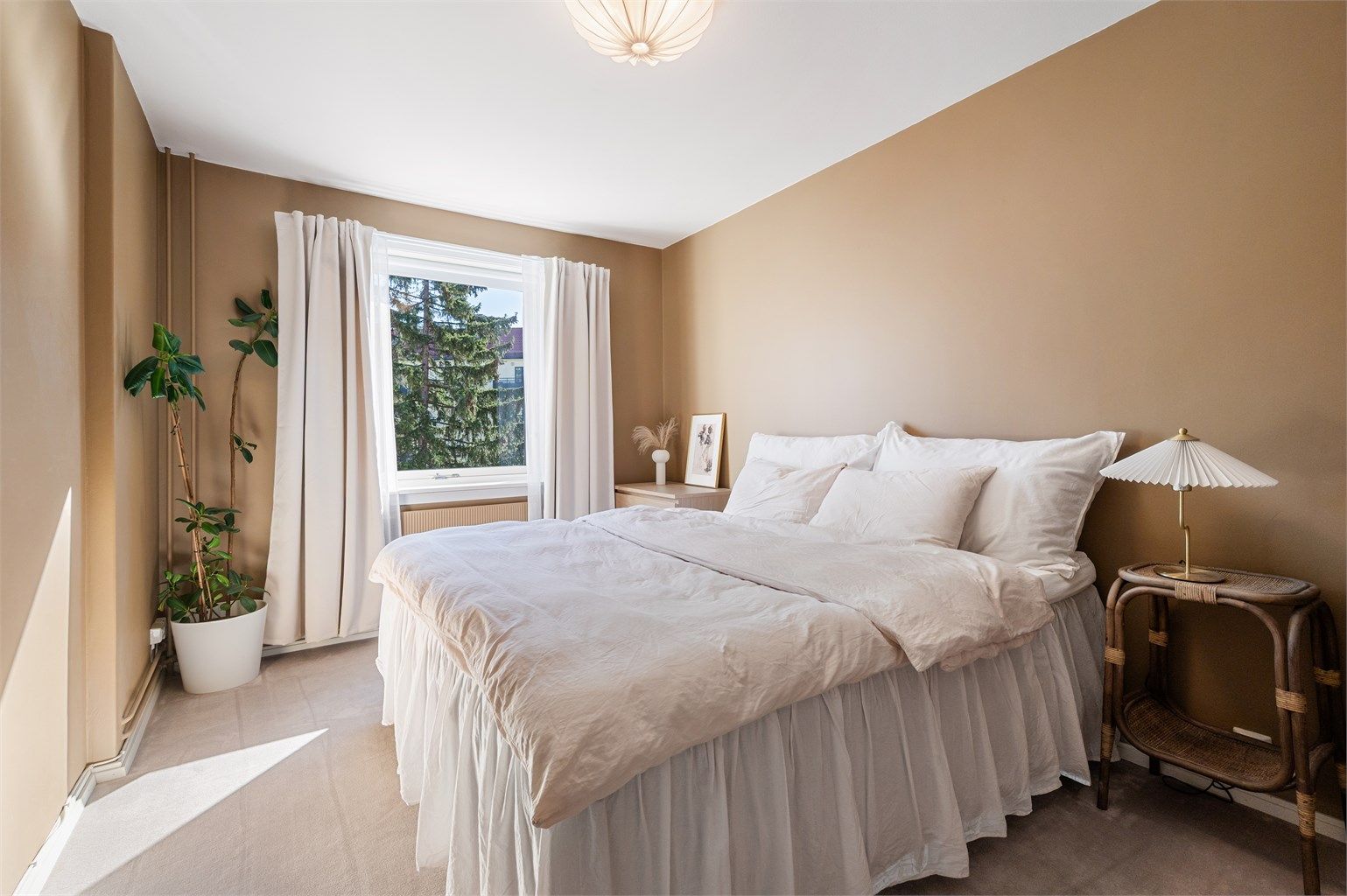 Leilighetens soverom har vegg-til-vegg teppe, og veggene er malt i en behagelig tidløs farge.