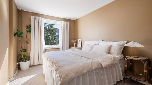 Leilighetens soverom har vegg-til-vegg teppe, og veggene er malt i en behagelig tidløs farge.