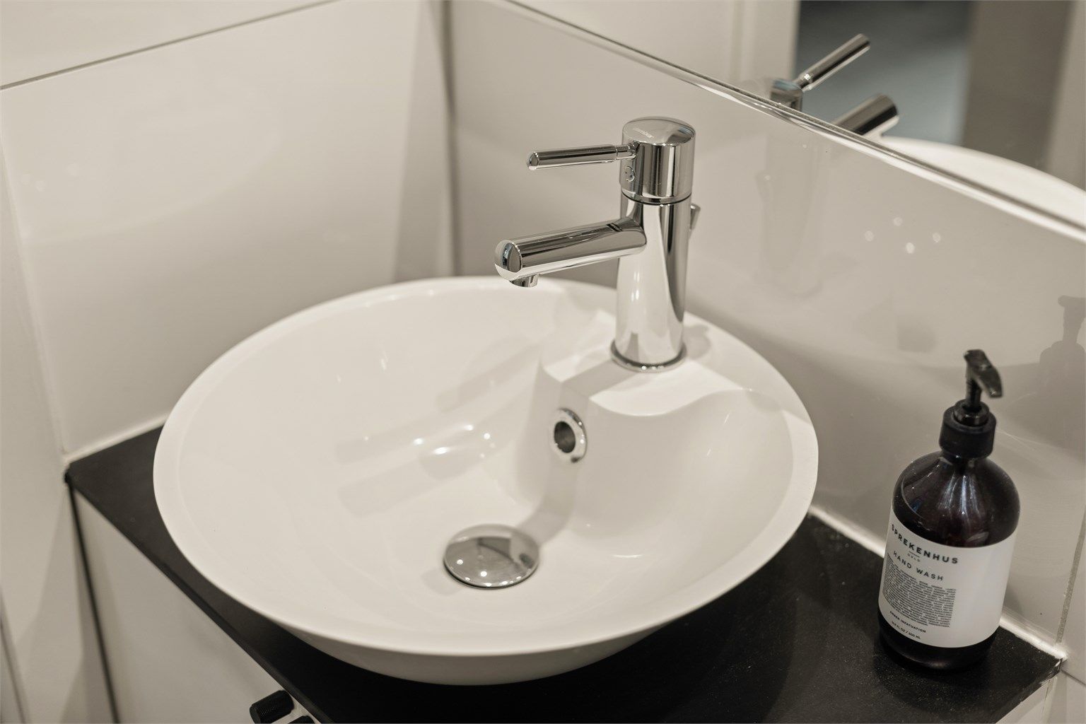 Stilren servantinnredning med speil og overlys gir badet et rent og tidløst uttrykk.