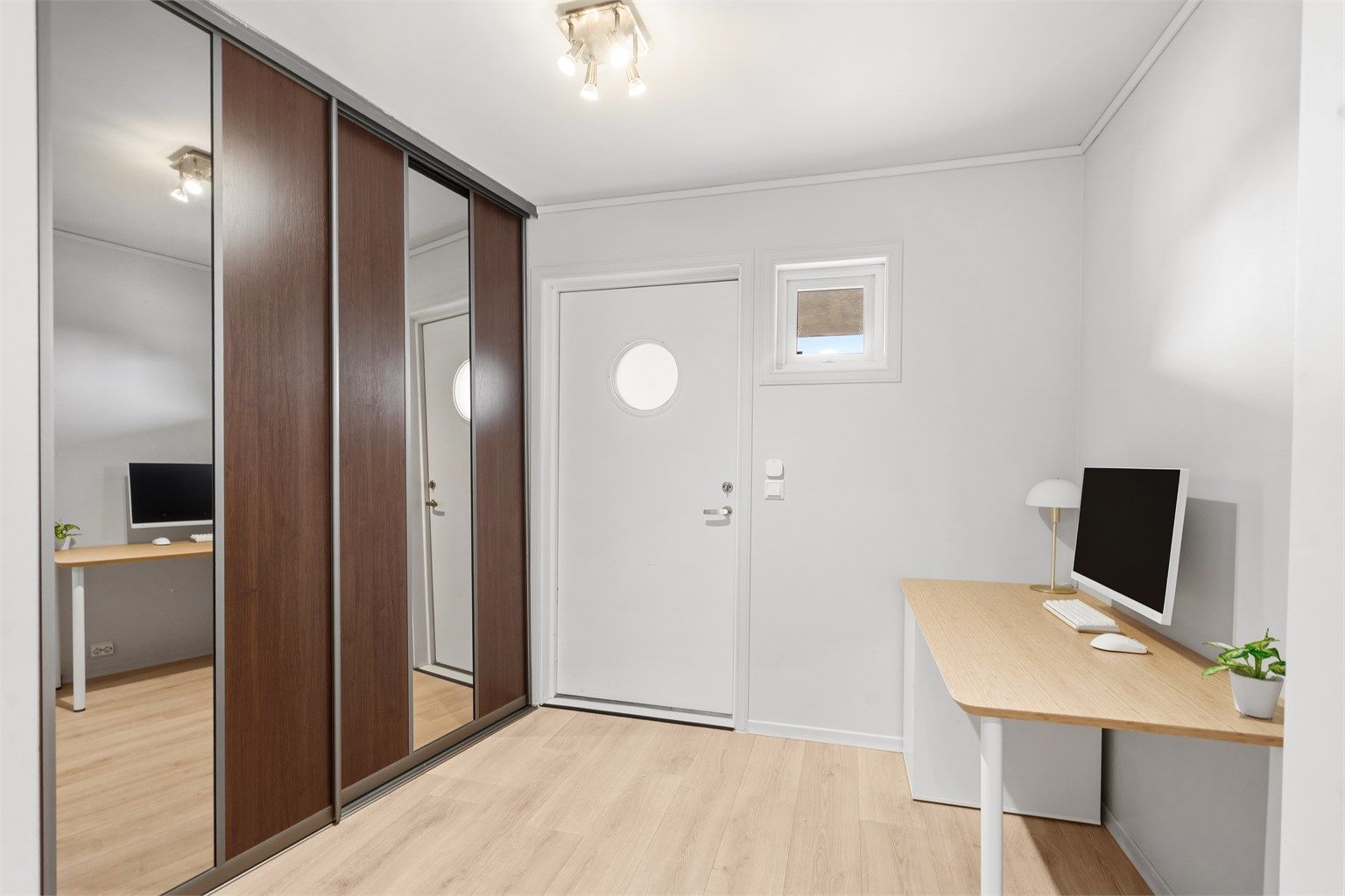 Velkommen inn. Entréen har laminatgulv og god plass til oppbevaring i en romslig skyvedørsgarderobe.