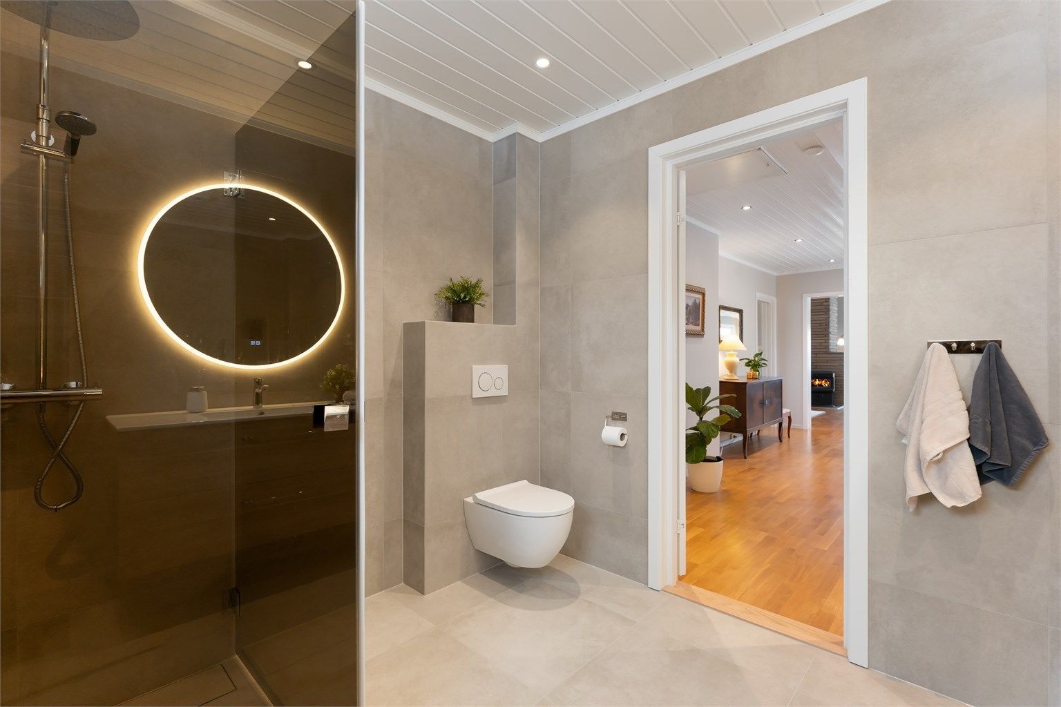 Badet har vegghengt toalett og flislagte overflater med behagelig gulvvarme.