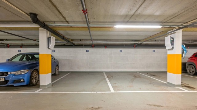 Romslige parkeringsplasser i nyere garasjeanlegg med el-bil lader.