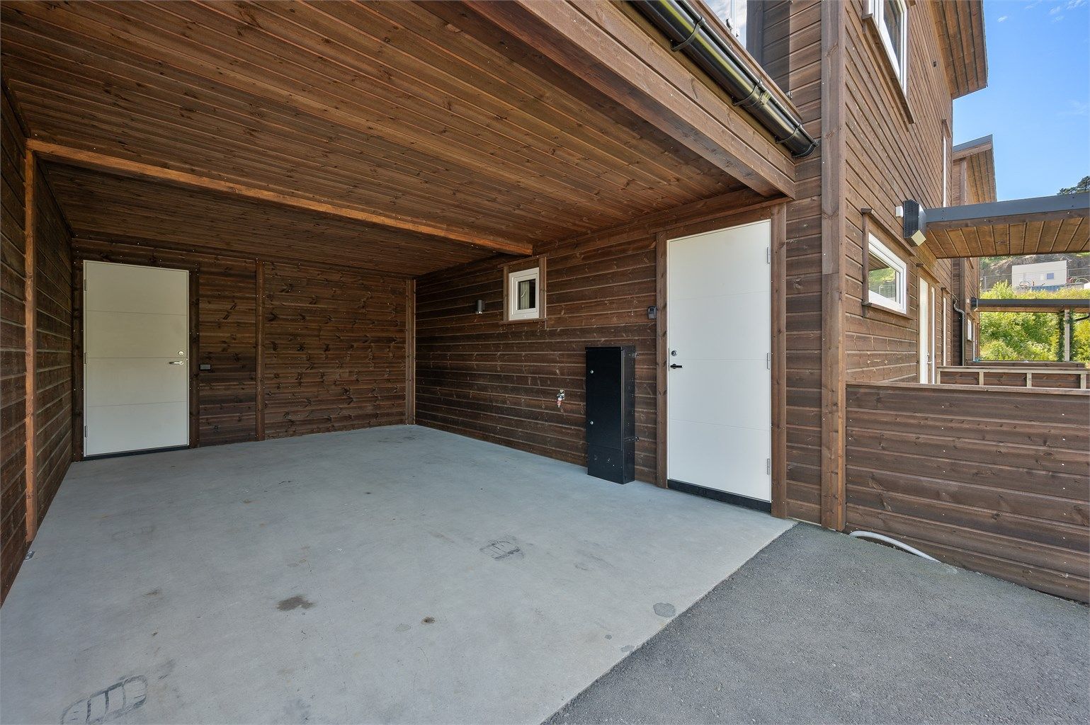 Carport med bod på innsiden. Den andre døren er direkte adkomst til vaskerommet.