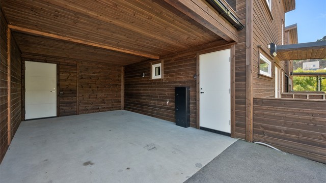 Carport med bod på innsiden. Den andre døren er direkte adkomst til vaskerommet.