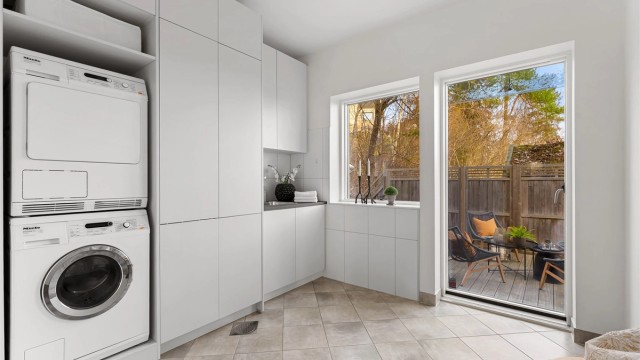 Vaskerom med flislagt gulv og varme med utgang til terrasse