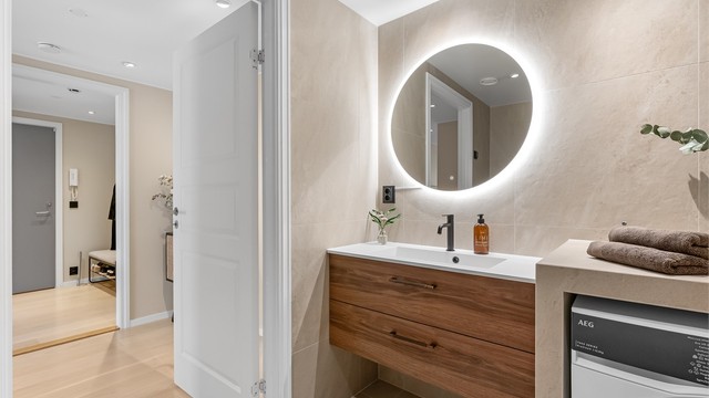 Badet har vegghengt toalett og dusjhjørne med innfellbare dører. Fordelerskapet for rør-i-rør-systemet er plassert her.