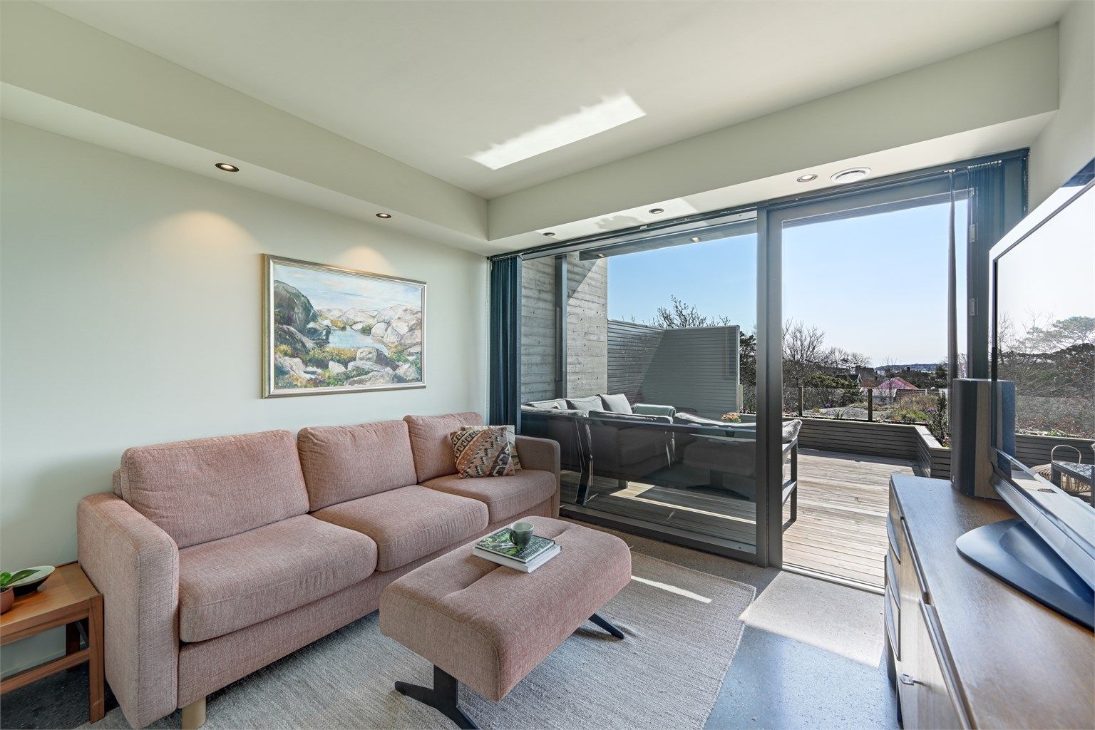 Et av soverommene i første etasje, her innredet som en ekstra stue. Rommet har utgang til en usjenert del av terrassen.