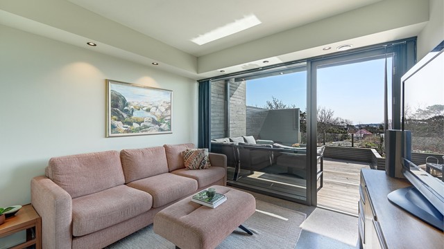 Et av soverommene i første etasje, her innredet som en ekstra stue. Rommet har utgang til en usjenert del av terrassen.