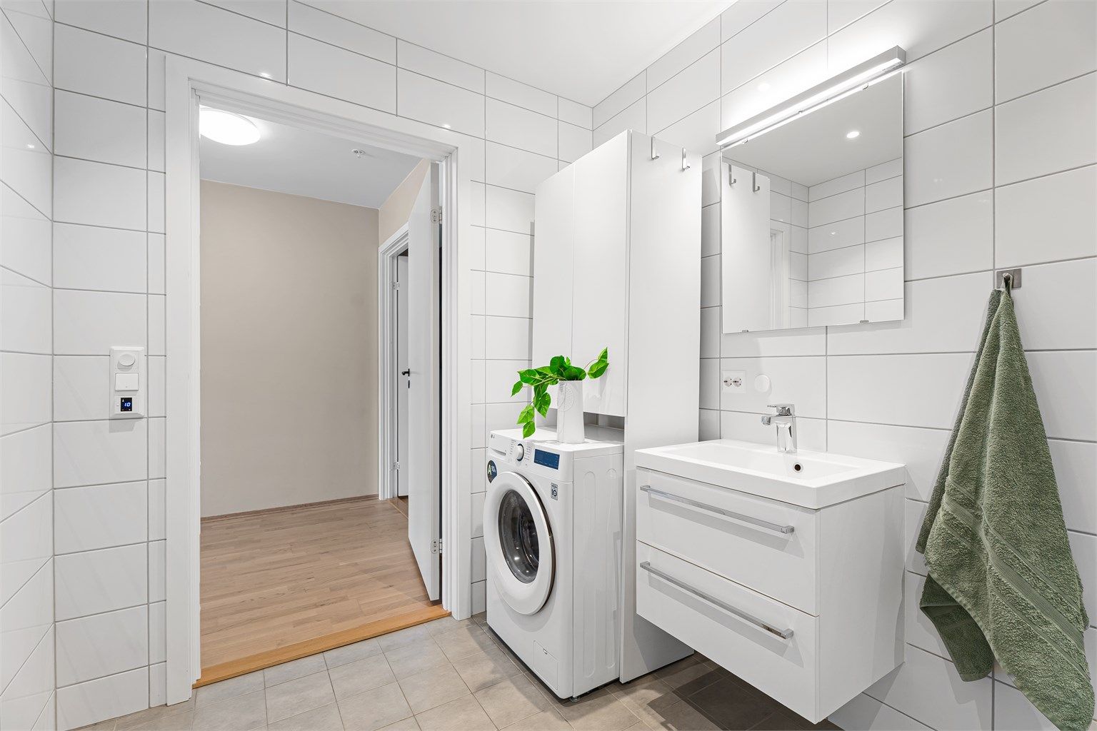 Det er downlights i himlingen og nisje med opplegg til vaskemaskin og eventuelt tørketrommel. Det er i dag satt inn en nisje med ekstra oppbevaringsskap. 