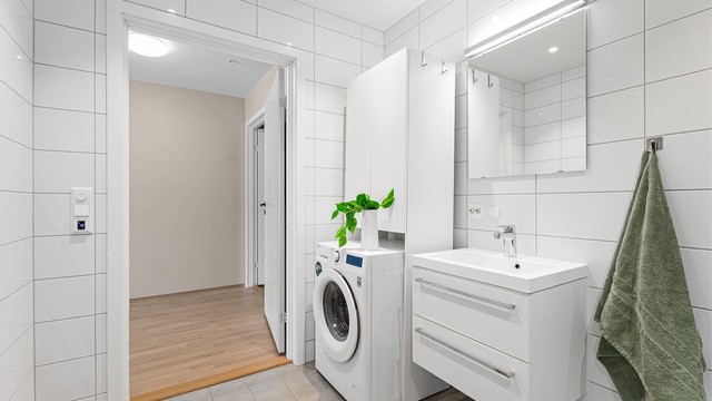 Det er downlights i himlingen og nisje med opplegg til vaskemaskin og eventuelt tørketrommel. Det er i dag satt inn en nisje med ekstra oppbevaringsskap.