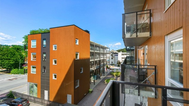 Leiligheten vender bort fra toglinjen, mot et rolig fellesområde.
