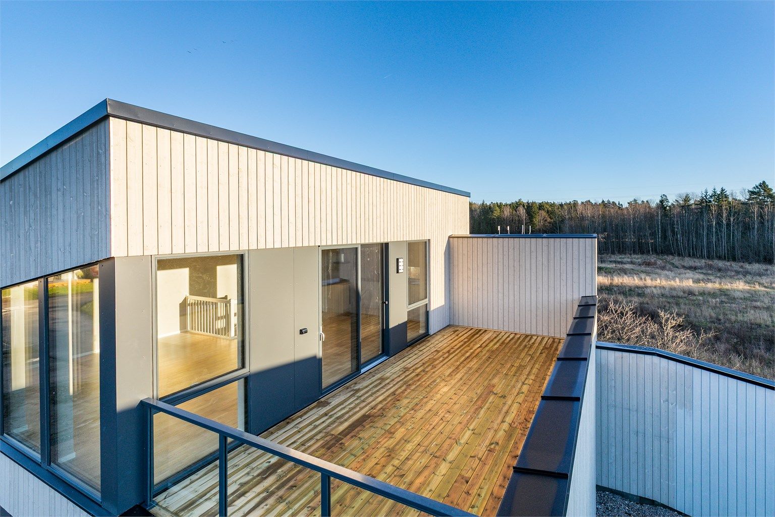 På altanen sees utsyn både over det nye nabolaget og til det tidligere åkerlandskapet i øst, rett bak boligen.