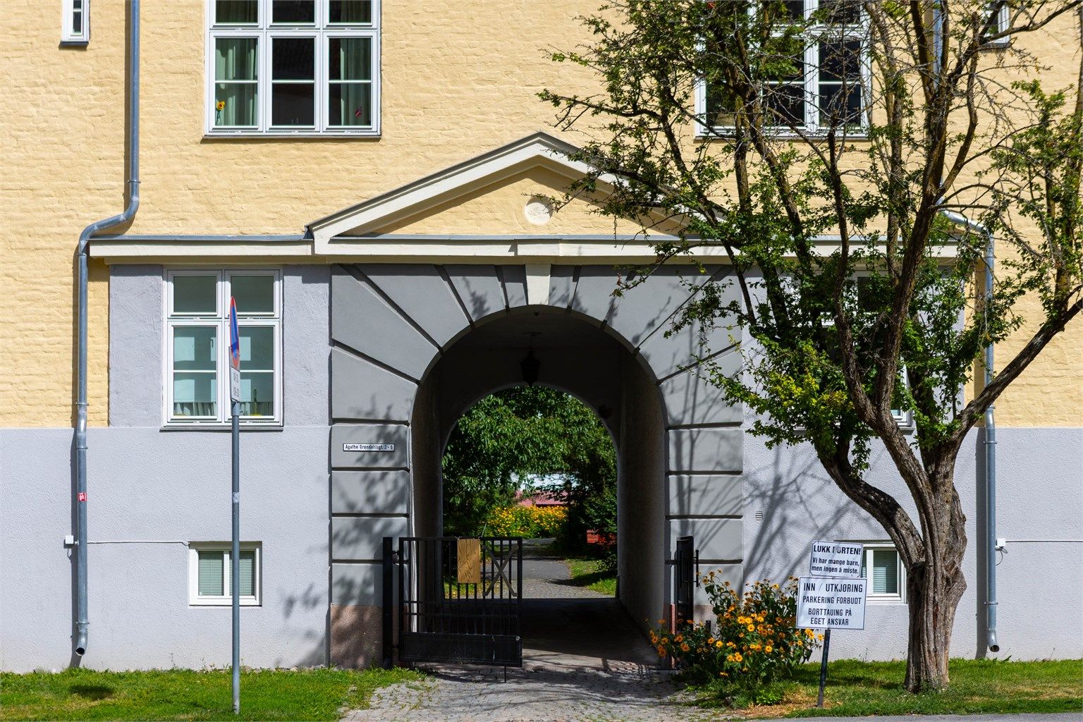 Gjennom portalen venter en frodig bakgård som føles mer som en liten park enn et tradisjonelt gårdsrom.
