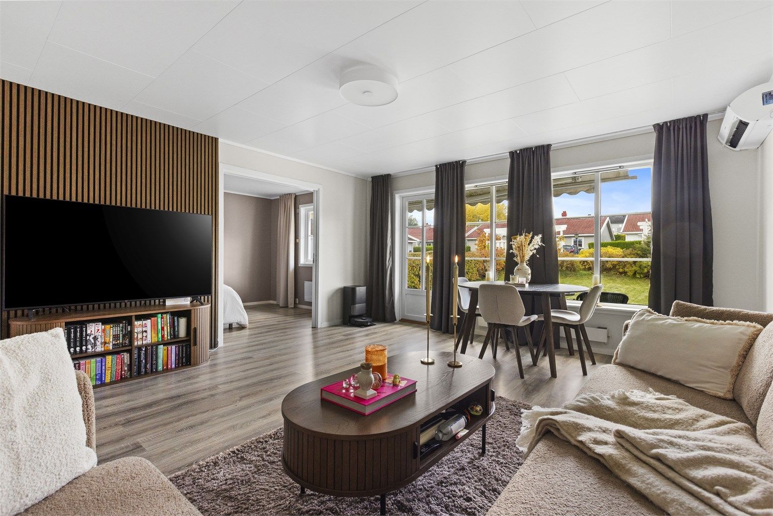 Lys og romslig stue med store vindusflater om slipper inn rikelig med naturlig lys. Fra stuen er det direkte utgang til en rolig og skjermet hage. Foto: A7 media