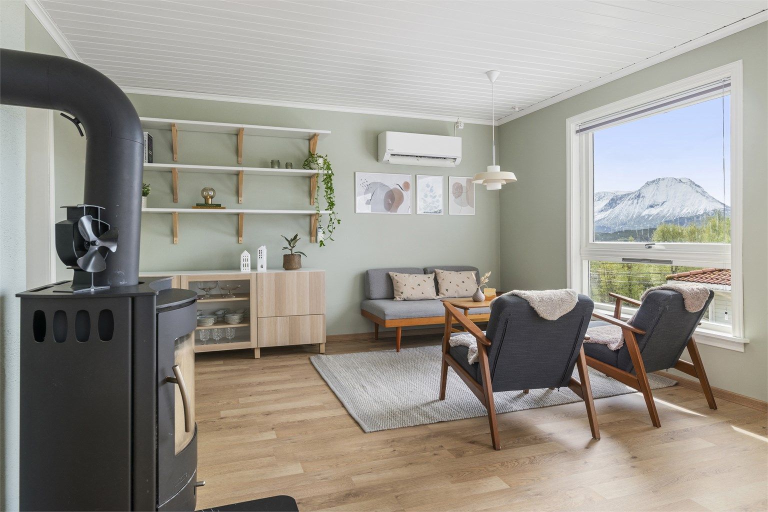 I enden av stuen, mot kjøkkenet er det i dag innredet med en trivelig loungesone, samt skjenk og dekorative hyller på vegg
