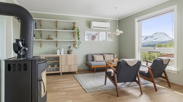 I enden av stuen, mot kjøkkenet er det i dag innredet med en trivelig loungesone, samt skjenk og dekorative hyller på vegg