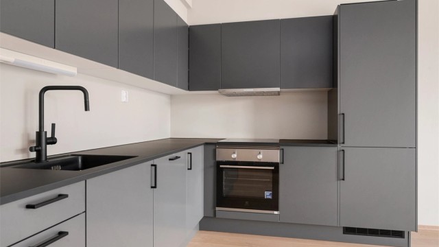 Kjøkkenet er utstyrt med innredning med mørke glatte fronter, benkeplate i laminat med nedfelt oppvaskkum med blandebatteri.