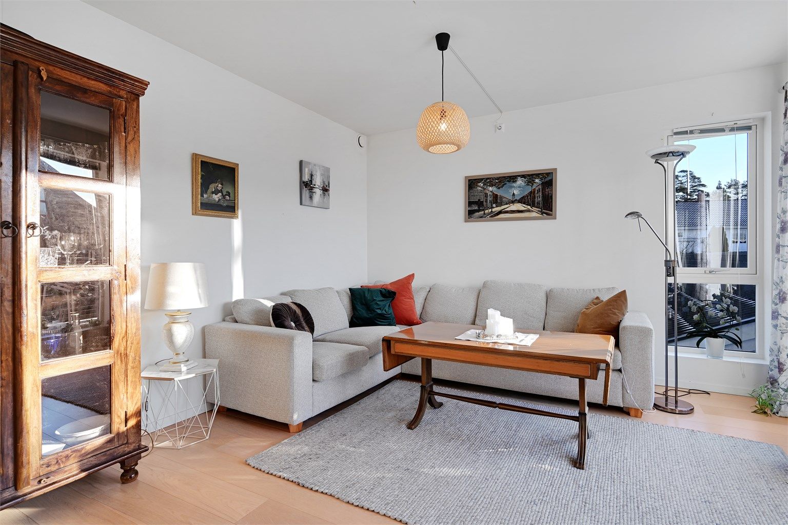 Stuen har god plass til både spisebord og sofagruppe, og store vindusflater gir rikelig med naturlig lys.