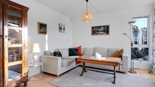 Stuen har god plass til både spisebord og sofagruppe, og store vindusflater gir rikelig med naturlig lys.