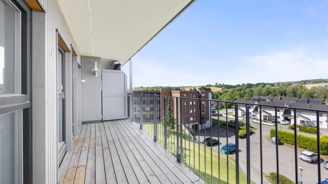 Romslig balkong med nye terrassebord og rekkverk, ferdigstilt i 2024.