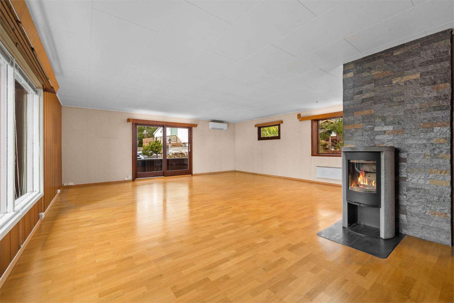 En effektiv peisovn med glassdør gir både varme og hygge. I tillegg er det installert en luft-til-luft varmepumpe i stuen.