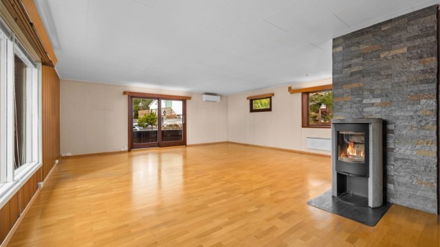 En effektiv peisovn med glassdør gir både varme og hygge. I tillegg er det installert en luft-til-luft varmepumpe i stuen.