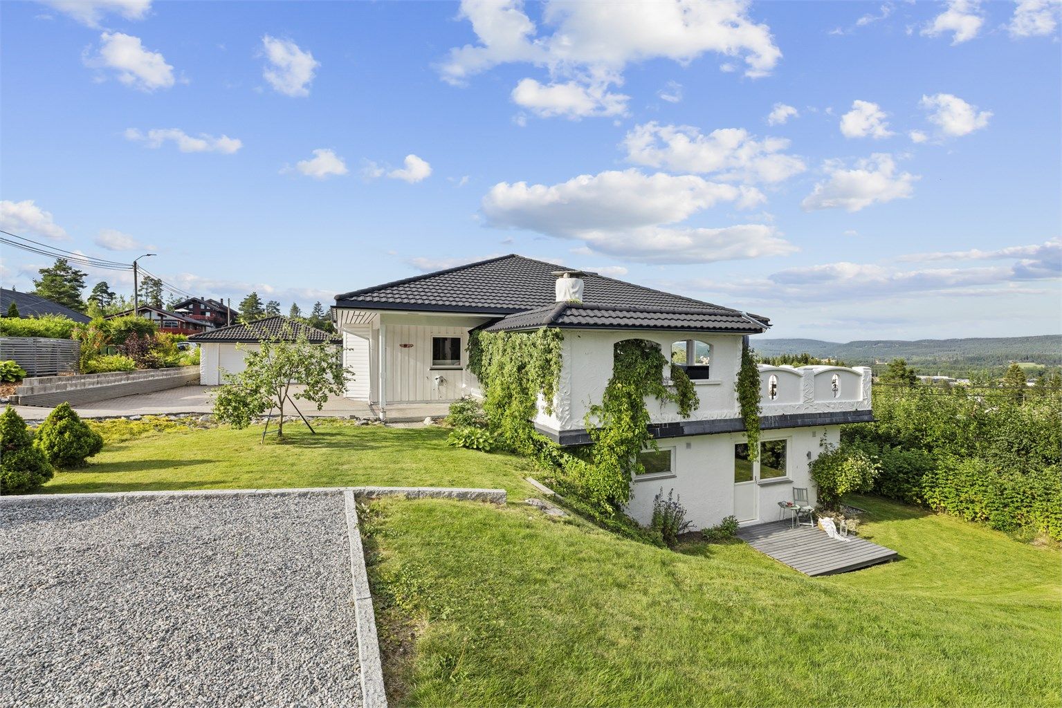 Pent opparbeidet tomt med plen, beplantning og tre ulike terrasser – her får du god plass til hele familien.

