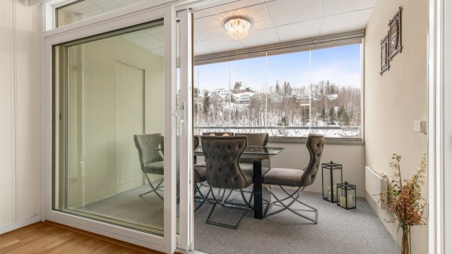 Skyvedøren i glass åpner opp og knytter stuen og balkongen sammen.