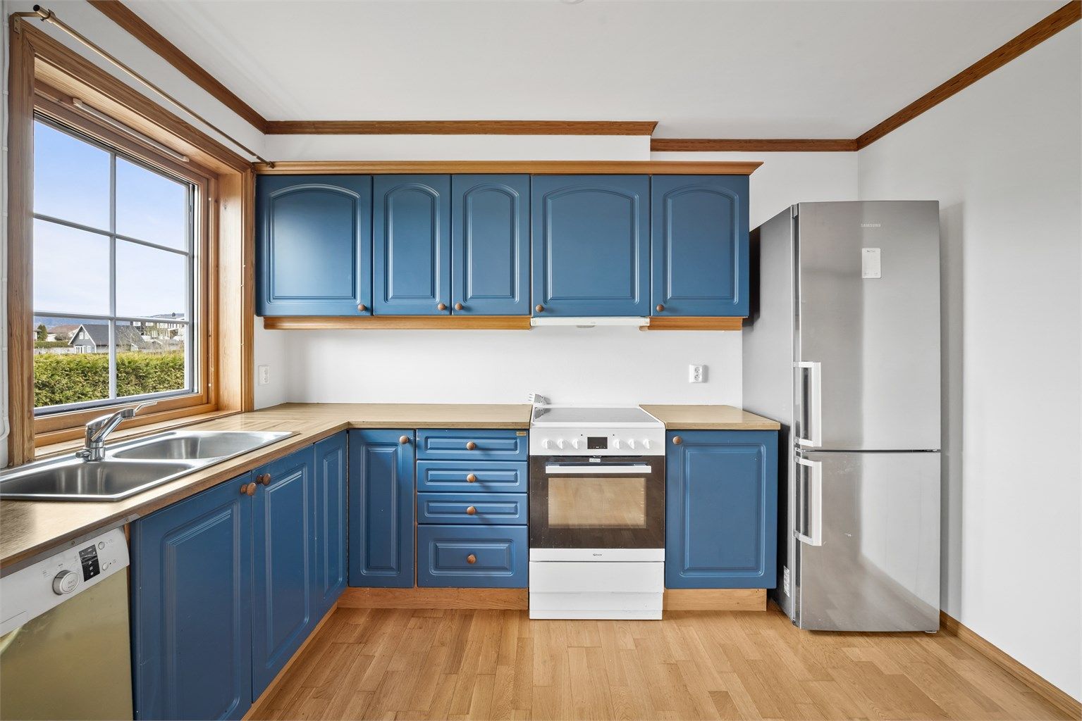 Kjøkkenet i underetasjen med profilerte fronter og benkeplate i laminat. Utstyrt med oppvaskkum og ventilator.