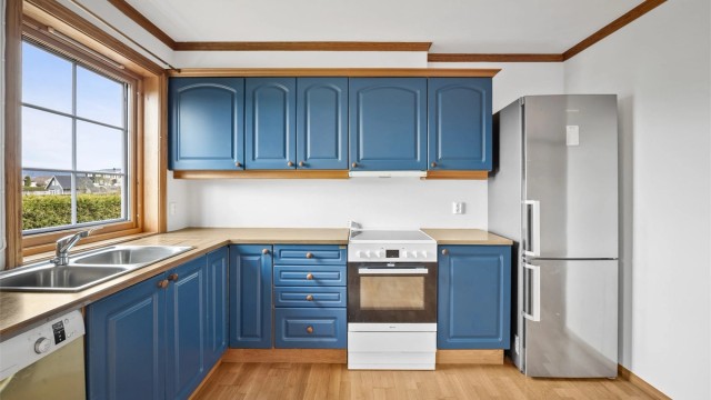 Kjøkkenet i underetasjen med profilerte fronter og benkeplate i laminat. Utstyrt med oppvaskkum og ventilator.