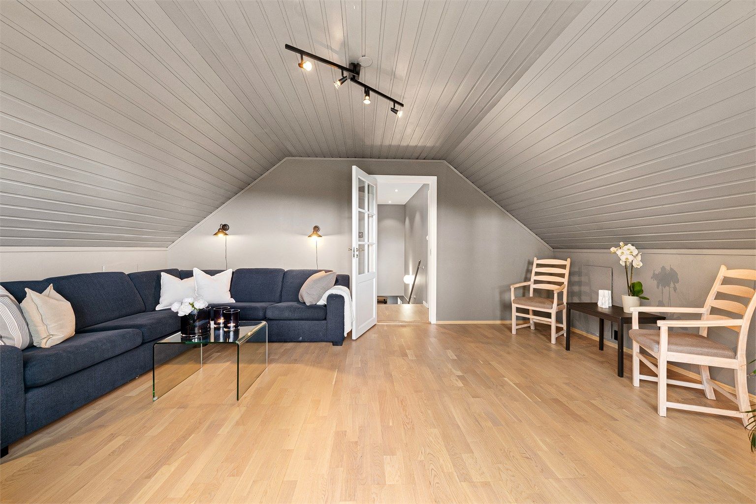 Romslig loftstue med god plass til en sofagruppe.