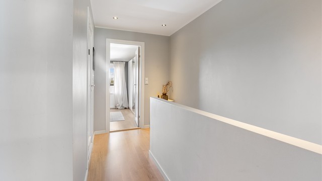 Gang i andre etasje med downlights og loftsluke til kaldt lagringsloft.