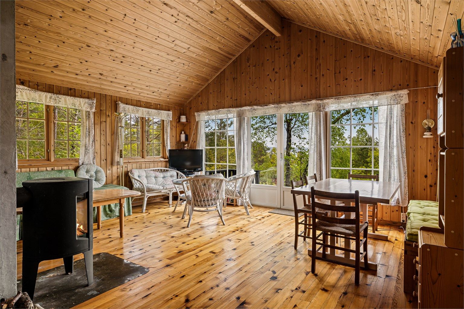 Stua har store vindusflater mot sjøen som gir lys og utsikt.