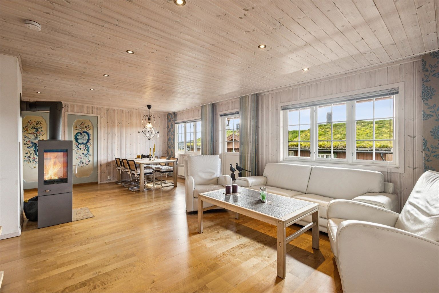 Fritidsleilighet over ett plan med peisovn, lune treoverflater og overbygd balkong.
Foto: EFKT