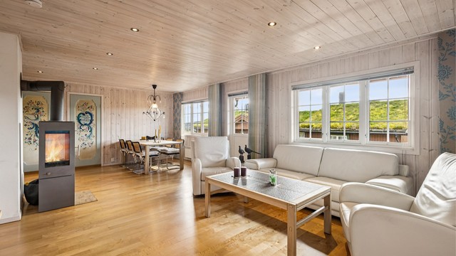 Fritidsleilighet over ett plan med peisovn, lune treoverflater og overbygd balkong.
Foto: EFKT