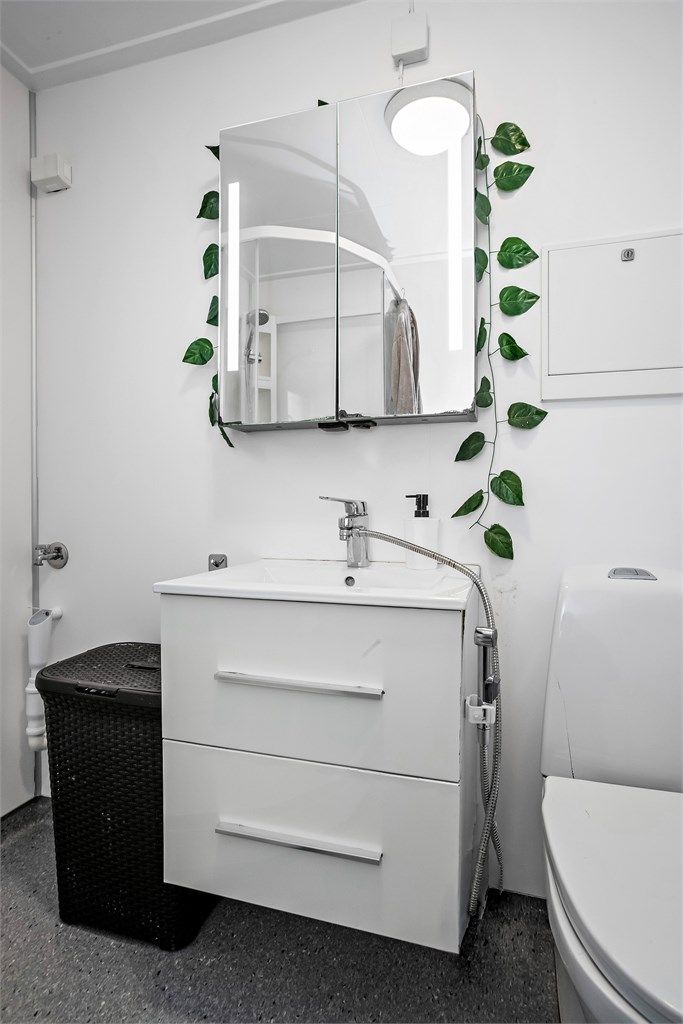 Badet har vegghengt servantinnredning med skuffer og speilskap med integrert belysning.