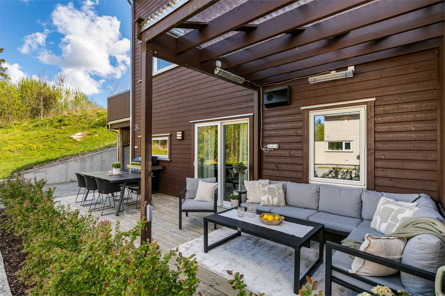 Pergola med tett tak utvider terrassens bruksmuligheter. Siden leiligheten ligger helt innerst i gaten er det svært lite som skjer foran terrassen.