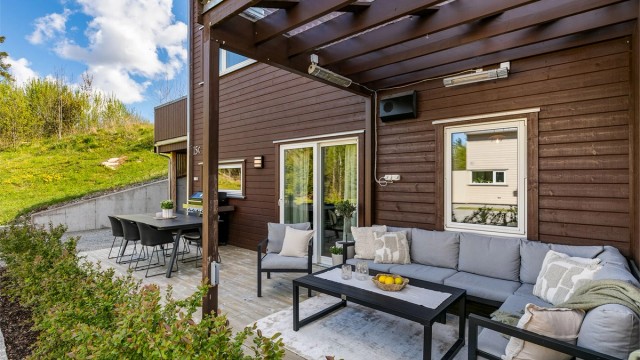 Pergola med tett tak utvider terrassens bruksmuligheter. Siden leiligheten ligger helt innerst i gaten er det svært lite som skjer foran terrassen.