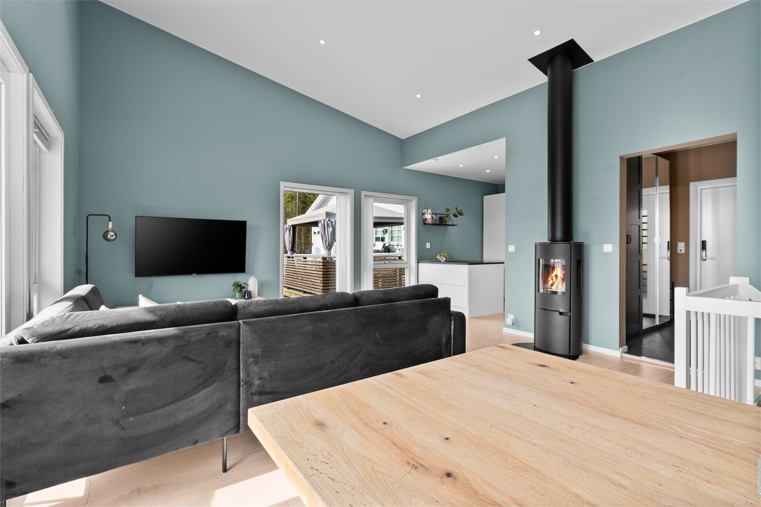 Fra spisestuen ser man tilbake mot sofakroken og inngangspartiet.