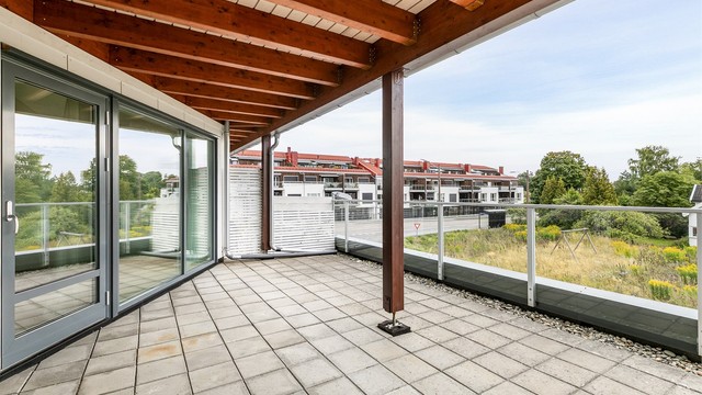 Mens terrassens ytre og åpne del er solfylt, er det svalende skygge å oppdrive under overbygget.
