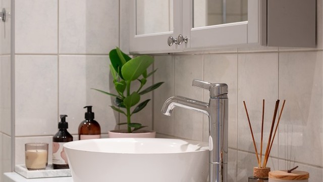 Baderomsinnredning med heldekkende servant og speilskap for oppbevaring.