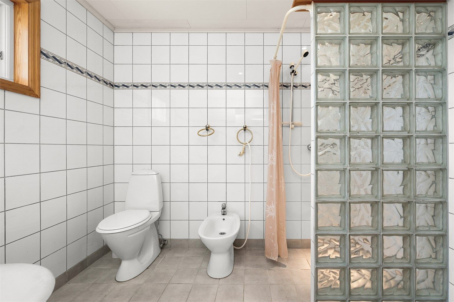 Badet har en praktisk planløsning med separat dusjsone, glassbyggerstein og god plass.