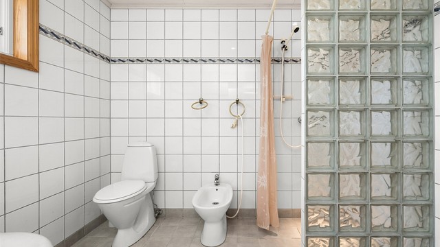 Badet har en praktisk planløsning med separat dusjsone, glassbyggerstein og god plass.