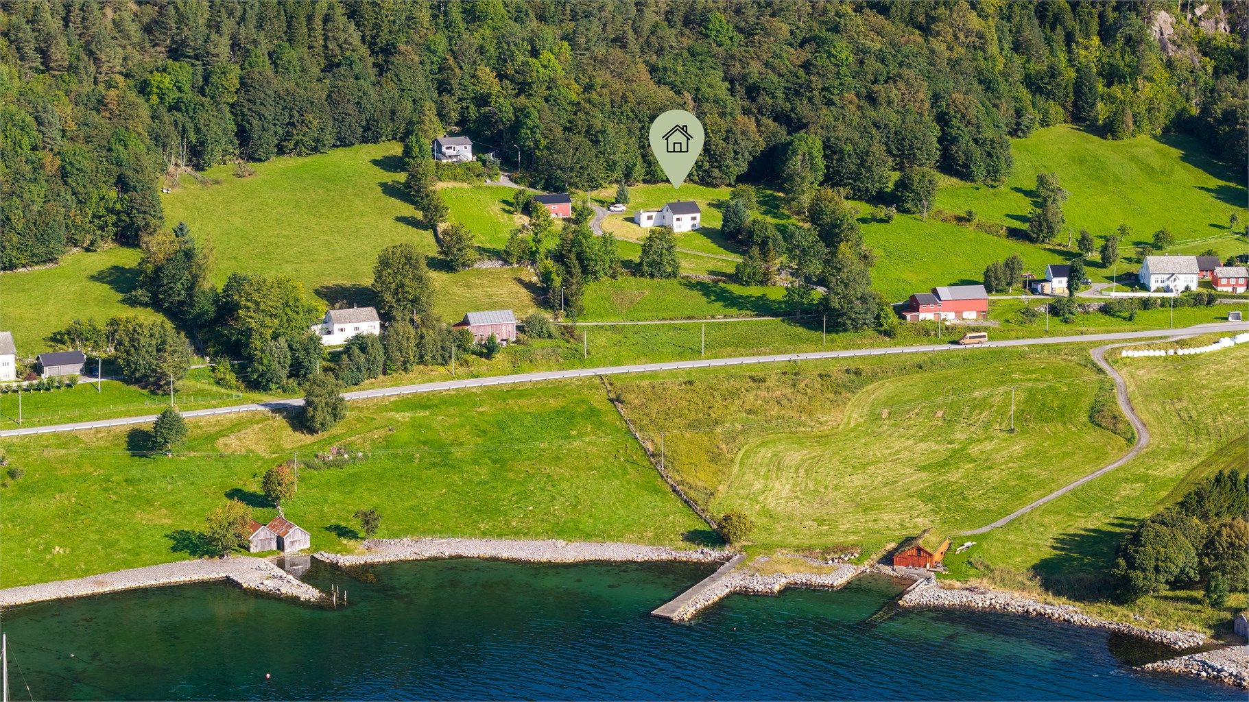 Slotsvika har strandlinje og naustmiljø langs vannkanten.